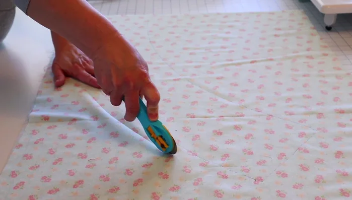 Trim the excess fabric using a rotary trimmer, leaving about a half to one inch of extra fabric beyond your drawn line.