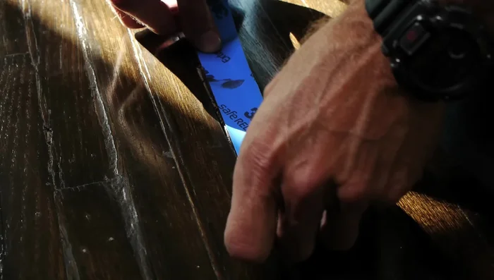 Tape off the area surrounding the gouge to protect the surrounding floor.