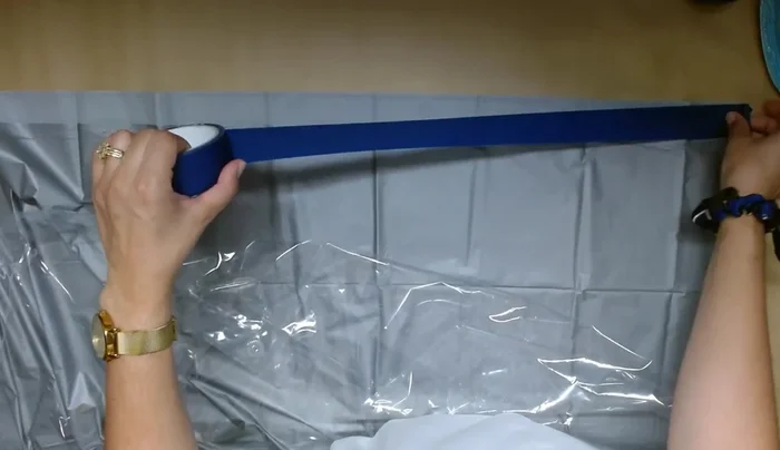 Attach the liners: Apply blue painter's tape along the top edges of both liners. Hot glue the two liners together along the taped edges, ensuring the plastic doesn't melt.