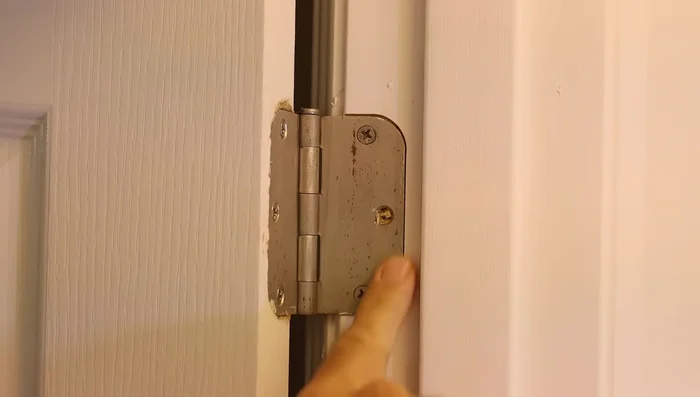 Replace short screws with longer ones: Use longer screws on the center hinge to firmly attach to the door jamb studs.