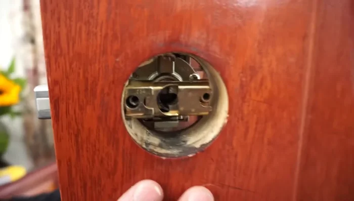 Hand-tighten the screws for the doorknob, ensuring proper alignment. Use a leveler to ensure everything is level before tightening fully.