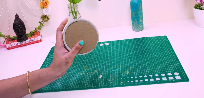 Attach the cardboard to the bottom of the base to close it.