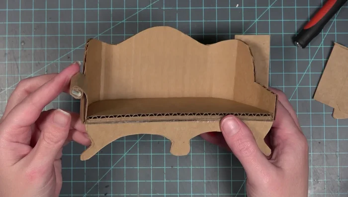 Cut and roll the arm pieces (single layer chipboard). Glue the rolled portions to the couch.