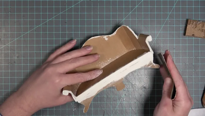 Apply a mixture of Elmer's glue and joint compound to the couch for a smooth, solid finish. Sand again.