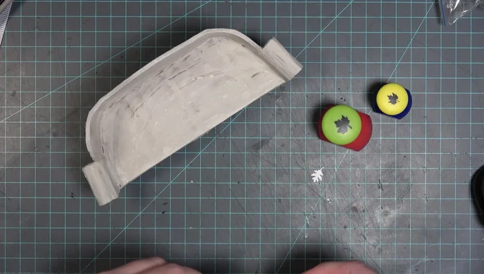 Paint the couch with a base coat of white acrylic paint, followed by a dry brush of gray for highlighting.