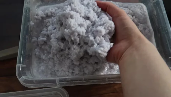 Prepare your mold and deckle: Add water and plenty of pulp to your container, stirring well to distribute the pulp evenly. Submerge the mold and deckle into the pulp. Lift straight up.