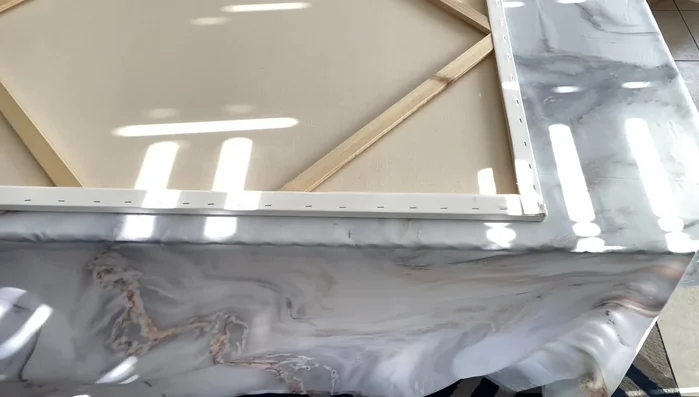 Fold and staple remaining sides: Fold the shower curtain edges neatly over the canvas edges and staple securely, ensuring a tight fit and no gaps.