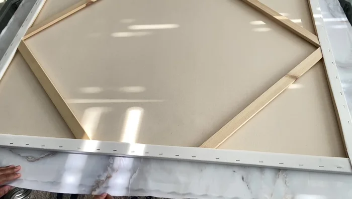 Fold and staple remaining sides: Fold the shower curtain edges neatly over the canvas edges and staple securely, ensuring a tight fit and no gaps.