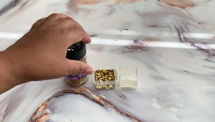 Add glitter (optional): Apply tacky glue or Mod Podge to desired areas and lightly sprinkle with glitter. Let it dry.