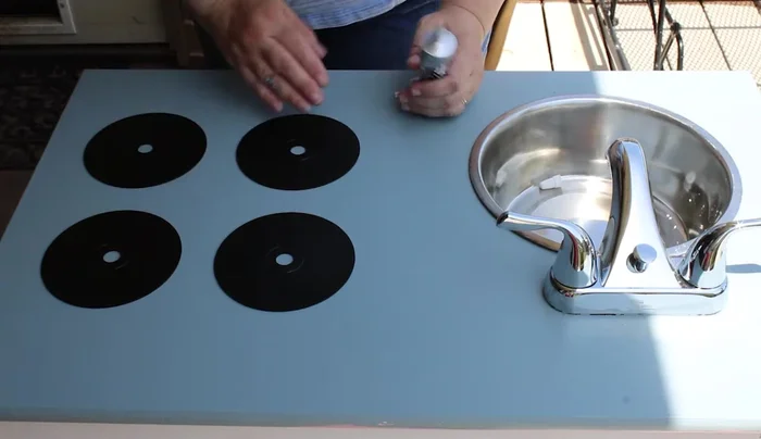 Install a clearance faucet from Lowe's, cutting holes and bolting it in from underneath.