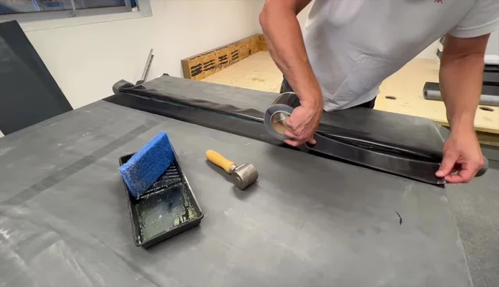 Use the seam tape roller to bond the seam tape to the primer, rolling along the length and sides.