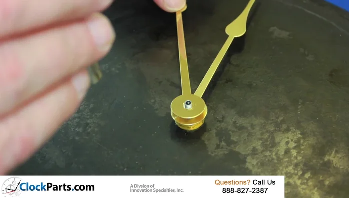 Thread the brass nut onto the top of the minute hand shaft.