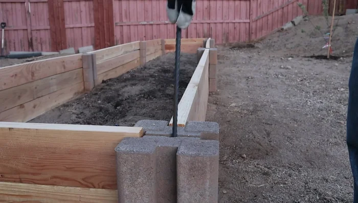 Insert rebar into the holes in each block stack to secure the structure.