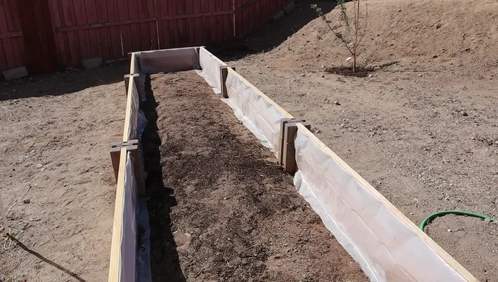 Fill the garden bed with soil, mixing it with existing soil if necessary.