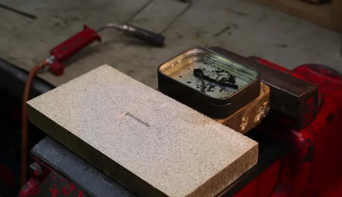 Quench the spring in oil again to complete the tempering process.