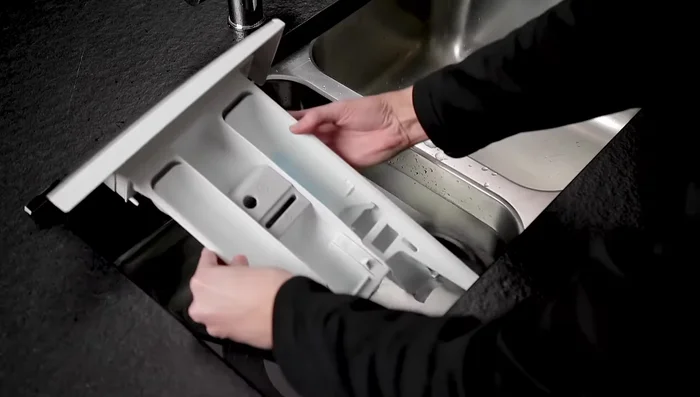 Soak the drawer in warm water to soften soap residue.