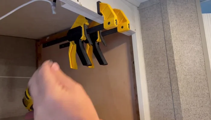 Secure the 1x2 wood with screws from the back, ensuring they only penetrate halfway into the face frame to avoid going through the front.