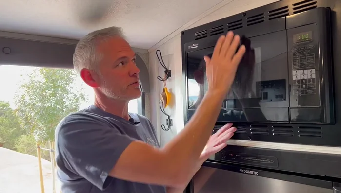 Reinstall the microwave frame by attaching the screws that secure it to the microwave, then the six screws attaching it to the camper.