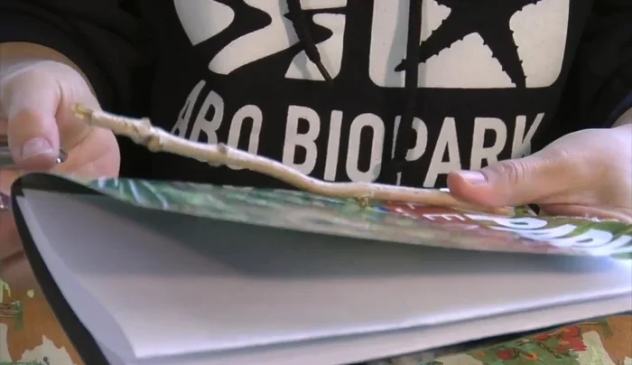 Use a twig (or straw/pencil) to measure and punch two holes through the calendar page and the paper sheets.