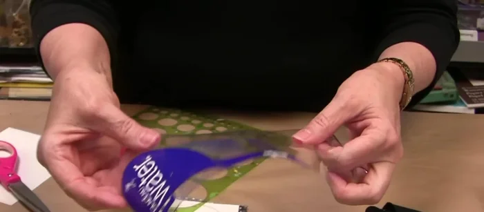 Cut a matching circle from peel and stick sheet and adhere to the water bottle circle.