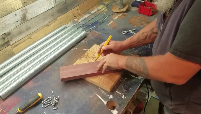 Drill a hole in the center of the longest pipe's bottom and attach a hanging mechanism (e.g., a bolt with washers and nuts).