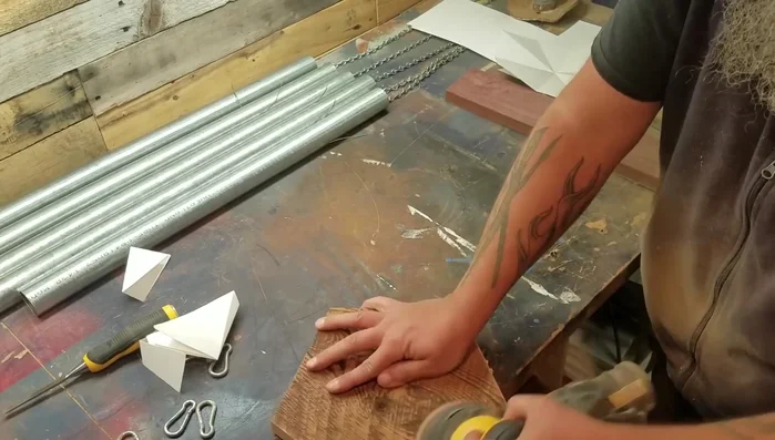 Drill a hole in the center of the longest pipe's bottom and attach a hanging mechanism (e.g., a bolt with washers and nuts).