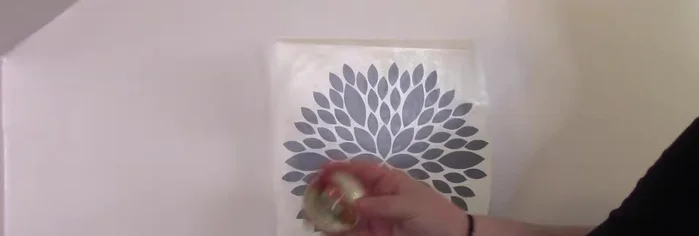 Apply the decal to your wall. Use a squeegee and/or a rubber burnishing ball to smooth out the vinyl and adhere it to the wall. Slowly peel away the transfer tape at a sharp angle.