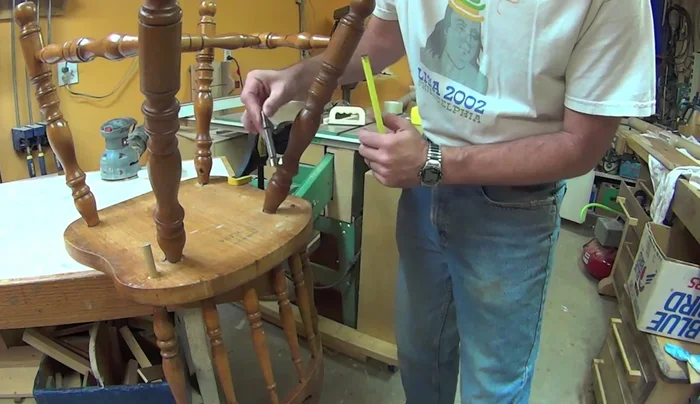 Use a forstner bit to carefully drill down to reveal the bottom of the broken spindle, guiding yourself to the previous dowel insertion location.