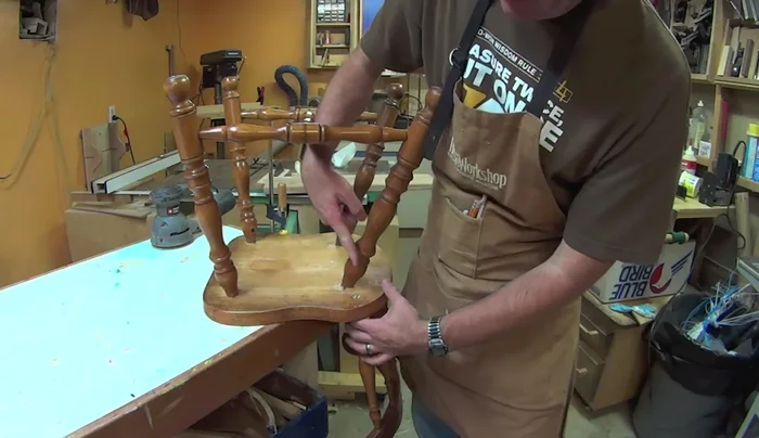 Use a forstner bit to carefully drill down to reveal the bottom of the broken spindle, guiding yourself to the previous dowel insertion location.