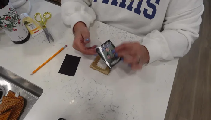 Apply the magnetic sheet to the back of each framed photo, ensuring complete coverage of the back of the frame.