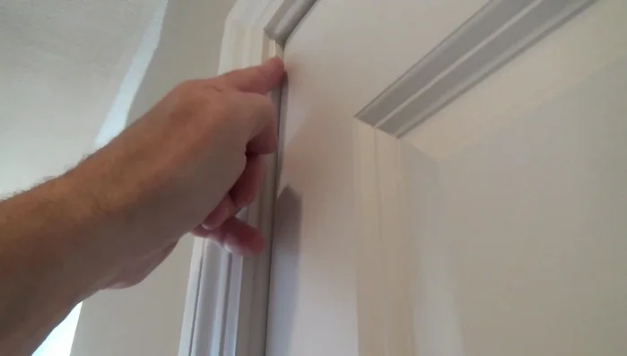 Clean old caulking and excess wood from the door stop area.