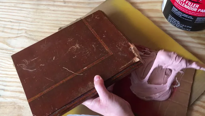 Press the hot glue mold onto the Bondo, ensuring good contact with the existing wood. Hold for a few minutes until the Bondo starts to harden.