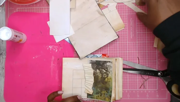 Add decorative elements: Glue embellishments, such as folded paper ruffles, to the pages and cover.