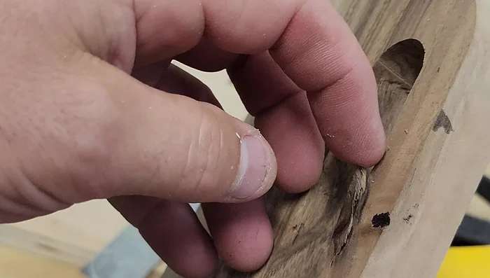 Address the cracked knot by super gluing it back in place and carefully routing around it. (Note: This step is presented as a possible solution and not always guaranteed to work.)