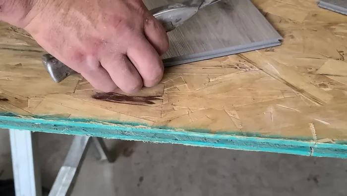 Completely cut the groove off the new plank using a utility knife, leaving only the tongue.