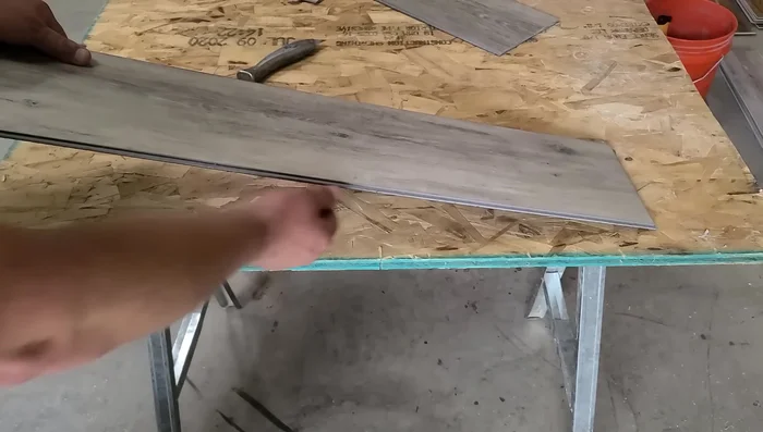 Completely cut the groove off the new plank using a utility knife, leaving only the tongue.
