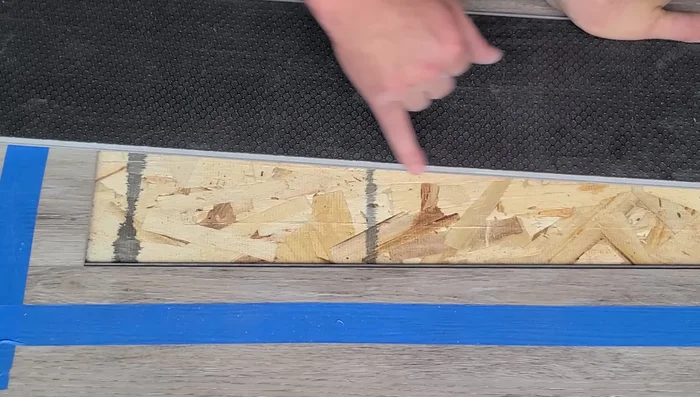 Tap the plank into place using a tapping block and rubber mallet, ensuring even pressure and avoiding damage.