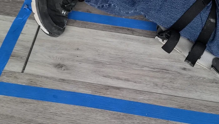 Tap the plank into place using a tapping block and rubber mallet, ensuring even pressure and avoiding damage.