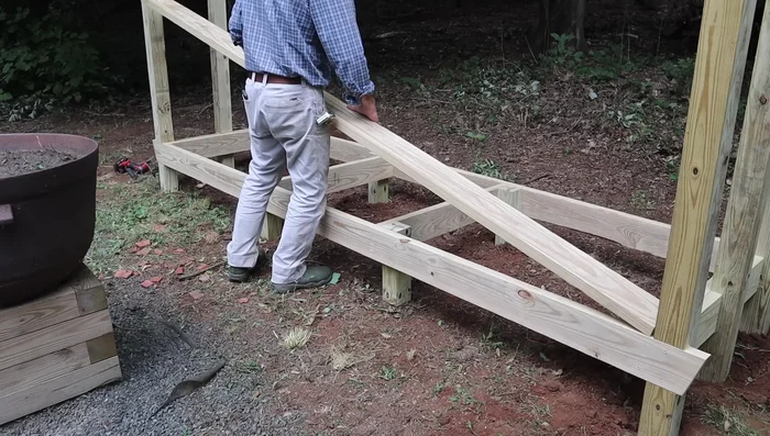 Reinforce frame: Attach the 2x6s and 2x10 to the 4x4 posts with 1/2-inch lag bolts; predrill holes for lag bolts.