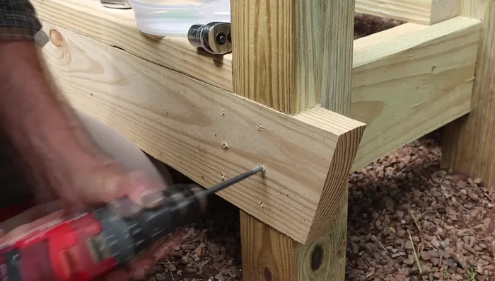 Reinforce frame: Attach the 2x6s and 2x10 to the 4x4 posts with 1/2-inch lag bolts; predrill holes for lag bolts.