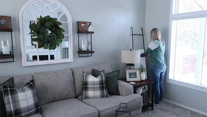 Decorating with a Blanket Ladder: Hang blankets on a ladder to balance the tall plant and conceal cable boxes.
