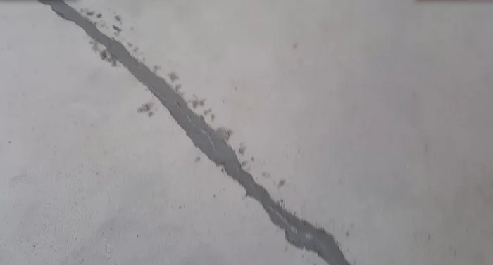 Grind off the excess repair material using a grinder with a vacuum attachment.