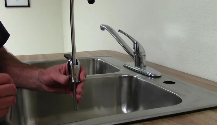 Install the faucet from the top, then tighten it from underneath the sink using a basin wrench if needed.