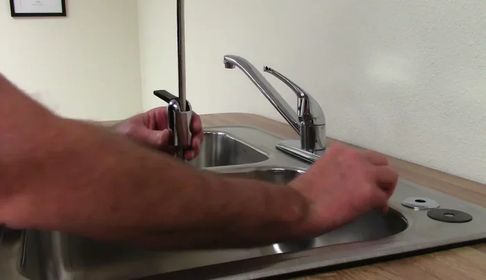Install the faucet from the top, then tighten it from underneath the sink using a basin wrench if needed.