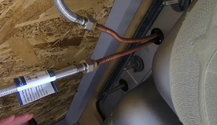 Install the bevel washer, lock washer, and nut onto the faucet shank from underneath the sink. Tighten securely using a basin wrench for better leverage.