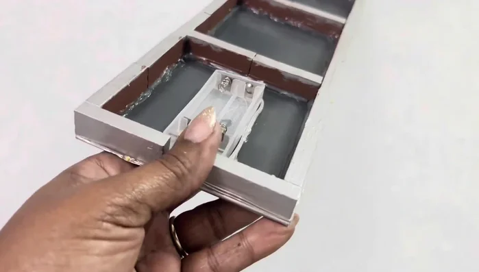 Secure the batteries using electrical tape, cutting away excess plastic to leave the bottom open for easy on/off access.