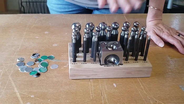 Shape the aluminum circles using a dapping and doming block set, working from largest to smallest size. Work slowly and carefully to avoid cracking the aluminum.