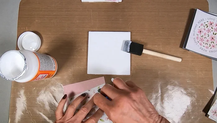 Apply Mod Podge to the back of the scrapbooking paper, extending to the edges.