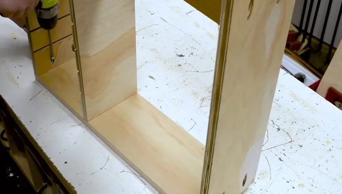 Apply wood glue, stand upright on front board. Screw end boards in place, check middle board spacing with a divider and squareness.