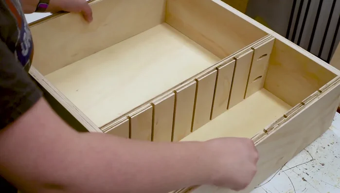 Cut plywood bottom to match box dimensions. Mark middle board position and attach with wood glue and brad nails.